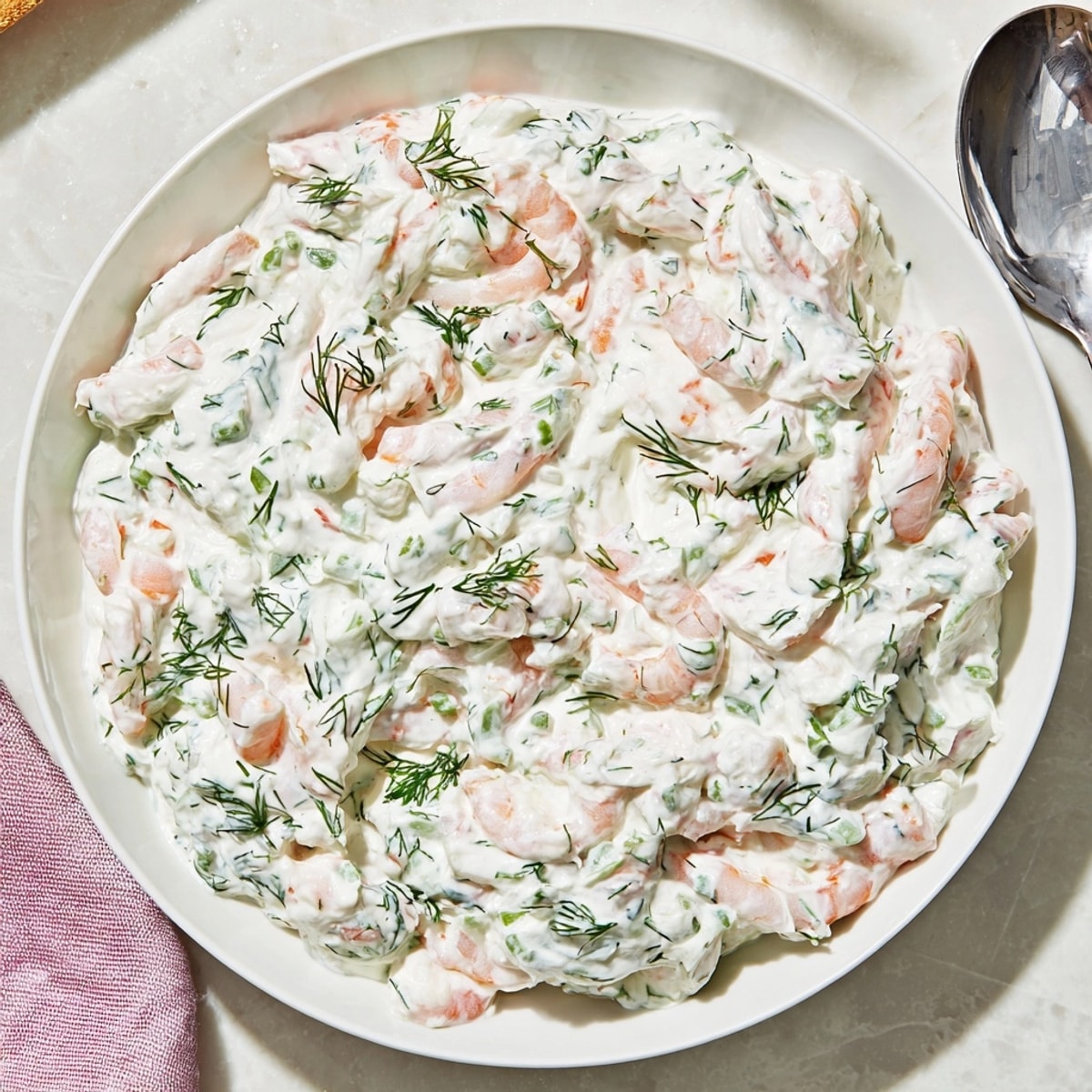 Creamy Shrimp Dill Yogurt Dip, speckled with herbs, nestled in a bowl ready for dipping.