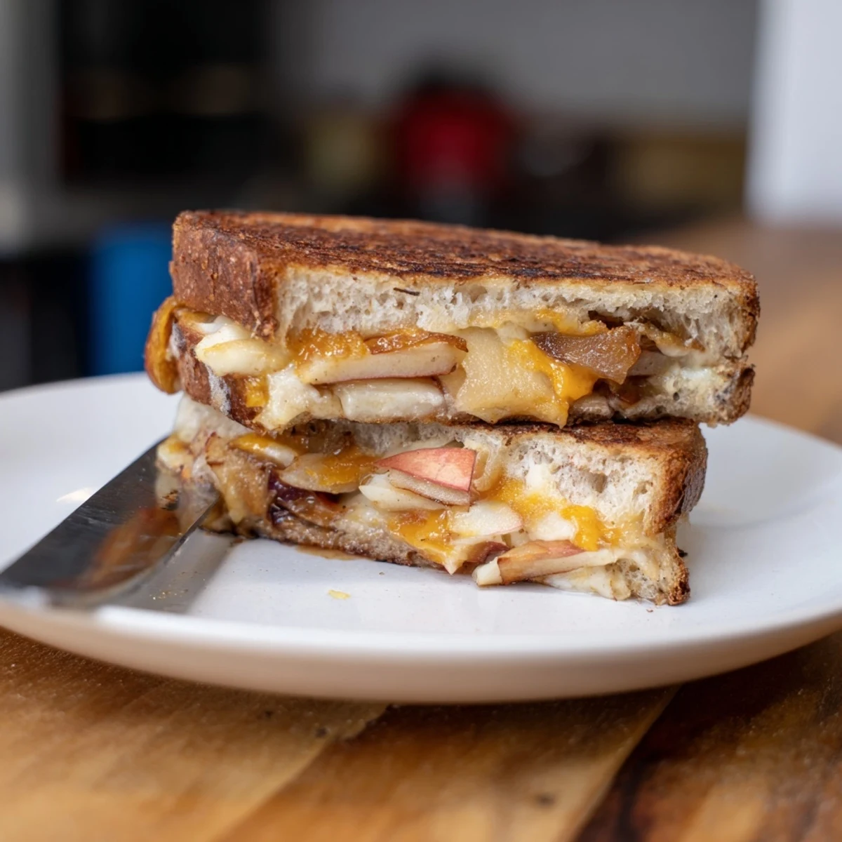 Melted cheese oozes from a Caramelized Onion, Apple & Cheddar Grilled Cheese, sandwiching sweet onions and crisp apples.