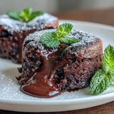 Warm Chocolate Lava Cakes with Espresso releasing molten chocolate from the center, served on a plate with vanilla ice cream melting on top.