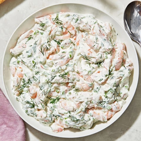 Creamy Shrimp Dill Yogurt Dip, speckled with herbs, nestled in a bowl ready for dipping.