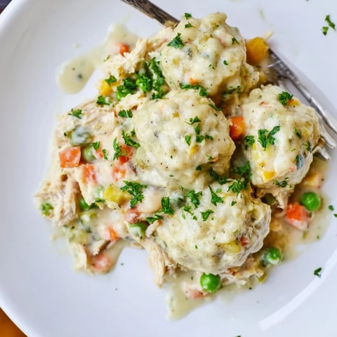Creamy Chicken and Dumplings Casserole topped with fluffy dumplings and fresh herbs.  