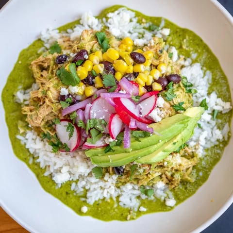Steaming Green Enchiladas Rice Bowl featuring chicken, black beans, corn, and fresh cilantro, ready to eat.