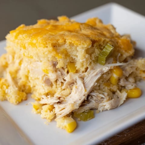 Southern Cornbread Chicken Casserole with a golden crust and savory chicken filling being served.