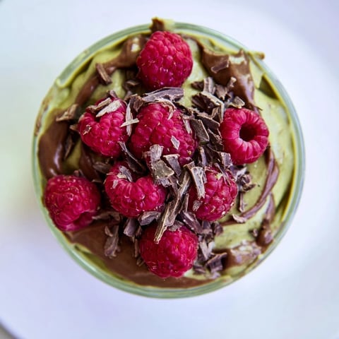 Silky smooth avocado chocolate mousse topped with bright red fresh raspberries, a stunning dessert.
