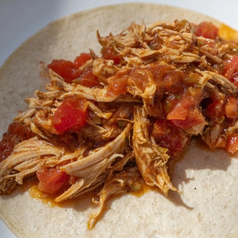 Crock-Pot Shredded Chicken Tacos spilling out of soft, warm tortillas, ready for fresh toppings.