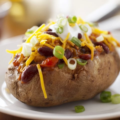 Steaming hot Chili-Style Baked Potatoes, loaded with a savory chili and cheddar cheese, perfect comfort food.