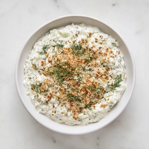 Creamy Fried Pickle Dip, ready to serve with crunchy chips and fresh dill garnish on top.
