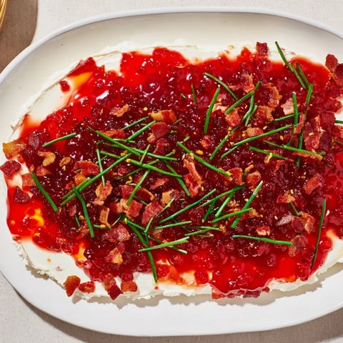 Delectable Easy Bacon Pepper Jelly appetizer: creamy cheese topped with glistening red pepper jelly and crispy bacon.