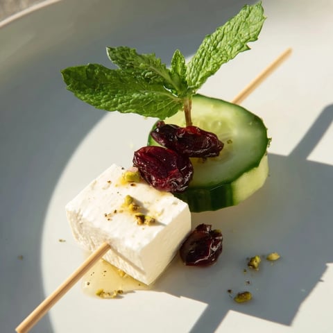 Vibrant Holiday Cranberry-Feta Skewers are ready to serve: feta, cranberries, and fresh mint on a skewer.