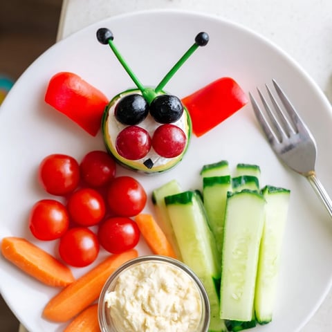 Coccinelle Amusante Planche Pique-Nique: vibrant ladybug-themed picnic platter with colorful veggies and creamy dips perfect for sharing.