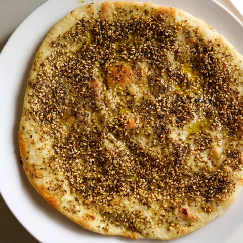 Golden, blistered Levantine zaatar bread, aromatic and savory, perfect for dipping or sharing.
