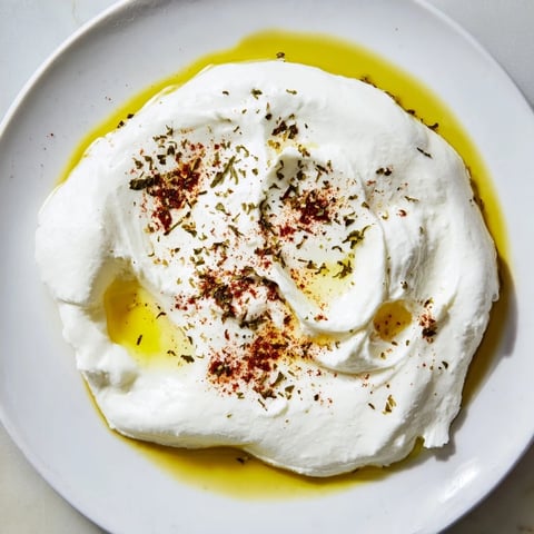 Creamy, homemade Levantine labneh cheese drizzled with olive oil, ready to be served with fresh pita.