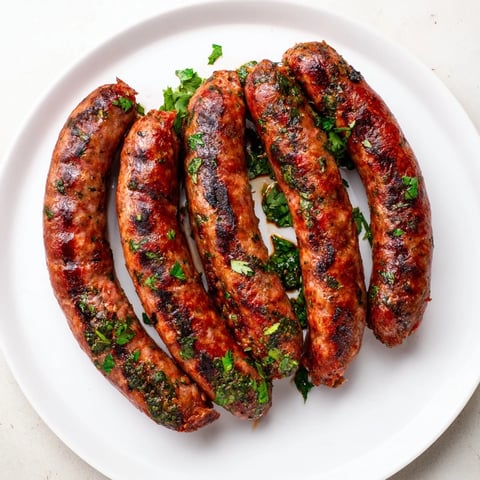 Juicy grilled Tunisian Merguez sausage links, sizzling atop a hot grill, ready to serve and enjoy.