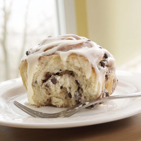 Warm, gooey Protein Cookie Dough Sweet Rolls with melted chocolate chips visible in the dough.