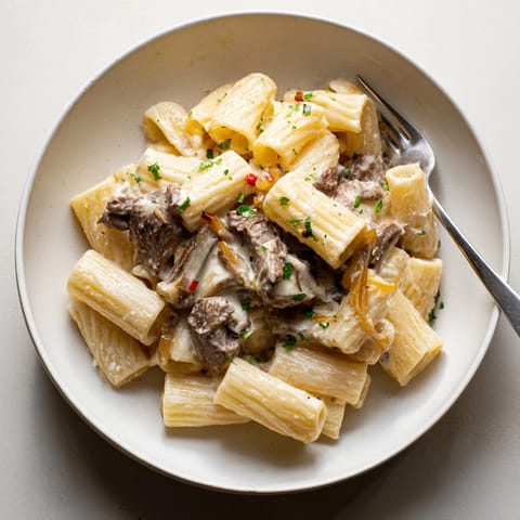 Hearty Philly cheese steak pasta served with creamy cheese sauce and colorful peppers.  