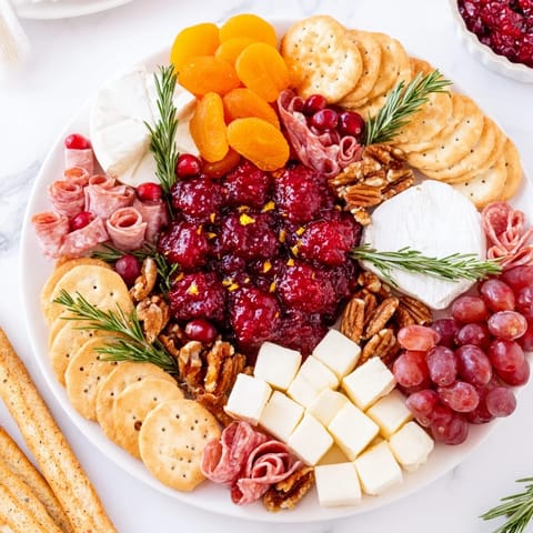 Festive Cranberry Wreath appetizer, visually striking with cheeses, grapes, and a glistening cranberry sauce center.