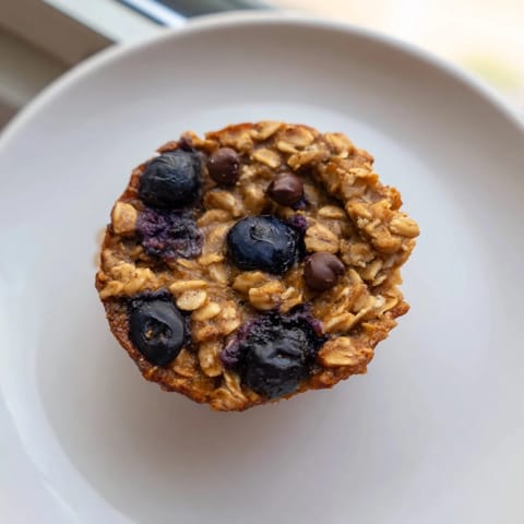 These warm, fluffy Baked Oatmeal Cups show a hint of cinnamon baked, ready to be enjoyed as a perfect snack.