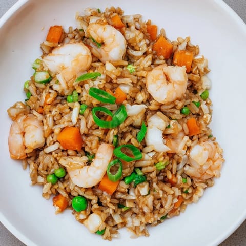 Close-up of savory shrimp garlic fried rice, showcasing the glistening shrimp and aromatic rice.