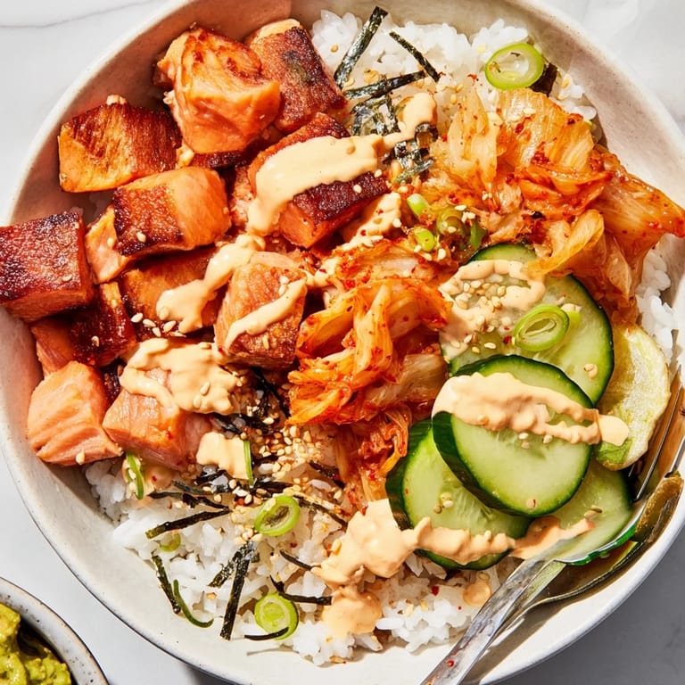 Enjoy a vibrant Crispy Salmon Rice Bowl with roasted nori and tangy kimchi.