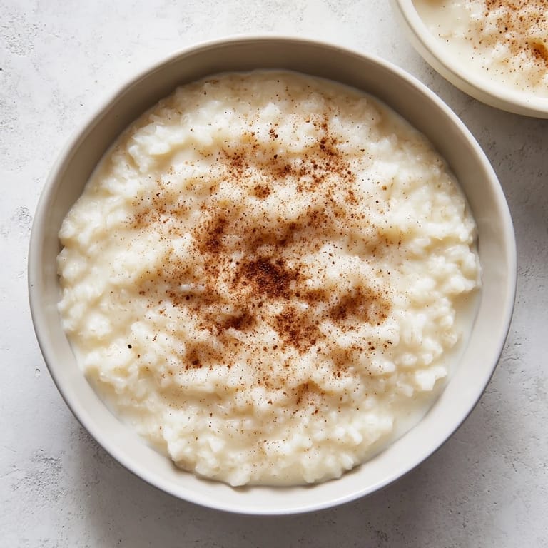 Creamy Rice Pudding with Leftover Rice, simmering gently in a saucepan, evoking warmth and sweetness.