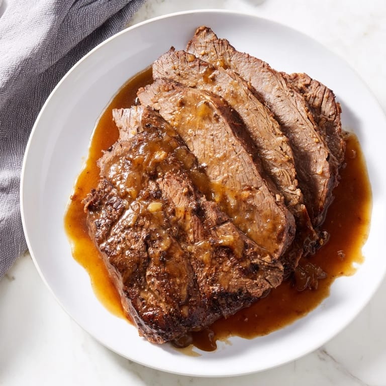A Dutch oven brimming with a Budget Holiday Chuck Roast, flavorful from the onion soup mix.