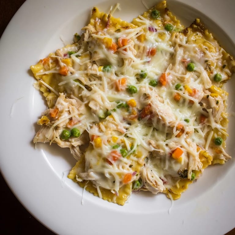 Creamy Chicken Pot Pie Ravioli Bake overflowing in a baking dish, a savory, cheesy American classic.