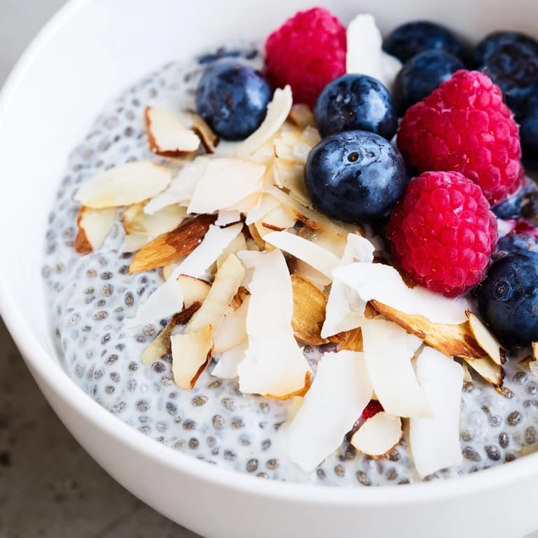 Healthy poppy seed chia pudding served in a bowl with berries and almonds, perfect for a gluten-free dessert.