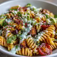 Easy Taco Pasta Salad bursting with colorful veggies, creamy dressing, and crunchy tortilla chips for a festive summer side dish.  